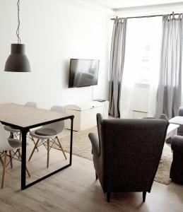 - un salon avec une table, des chaises et une télévision dans l'établissement Ferienwohnung Charlotte, à Glücksburg