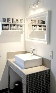 W łazience znajduje się biała umywalka i lustro. w obiekcie Ferienwohnung Charlotte w mieście Glücksburg