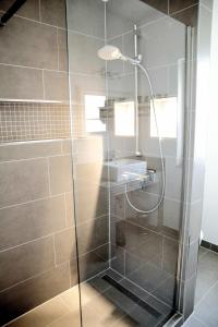 La salle de bains est pourvue d'une douche avec une porte en verre. dans l'établissement Ferienwohnung Charlotte, à Glücksburg