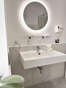 a white bathroom with a sink and a mirror at Il vecchio Fauno in Pompei