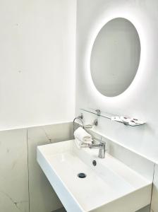 a white bathroom with a sink and a mirror at Il vecchio Fauno in Pompei