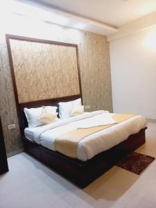 a bedroom with a large bed with white sheets and pillows at Hotel Green Lotus By Dsy Hospitality in Noida