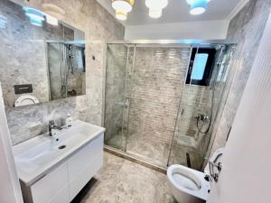 uma casa de banho com um chuveiro, um lavatório e um WC. em Solid Residence Sea View em Mamaia