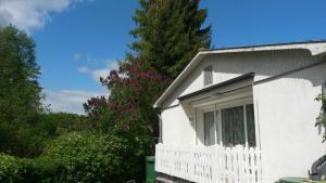 a white house with a white fence and trees at Ferienhaus am See in Krakow am See