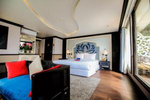 a bedroom with a large white bed and a couch at Lotus D'Orient Cruise in Ha Long