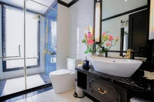 y baño con lavabo, aseo y espejo. en Lotus D'Orient Cruise, en Ha Long
