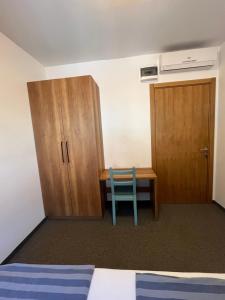 Zimmer mit einem Schreibtisch, einem Schrank und einem Stuhl in der Unterkunft Terasa in Novi Sad