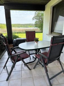 - une table et des chaises sur une terrasse avec vue sur un champ dans l'établissement Ferienhaus am See auf großem Grundstück, Kaminofen, à Krakow am See
