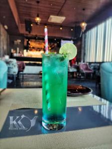 a green drink with a paper straw sitting on a table at Red Orchid Hotel Kanpur in Kānpur