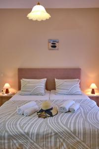 Una cama con dos toallas y dos sombreros. en Houmis Apts & Studios en Agios Georgios Pagon