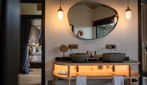 une salle de bain avec deux lavabos et un miroir dans l'établissement Euphorbia Mashatu, à Lentswelemoriti