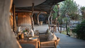 Lentswelemoriti的住宿－Euphorbia Mashatu，木制甲板上配有桌椅