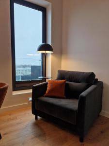 a black couch in a room with a window at Artisa Riia Str 22 XXL Luxury Penthouse Apartment in Tartu