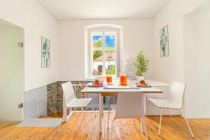 a white dining room with a table and chairs at Komló Apartman - Mátyás in Kőszeg