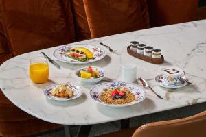 a white table with plates of food and orange juice at Bulgari Hotel Shanghai in Shanghai