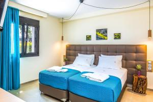 KondomárionにあるVilla Veggera Chaniaのベッドルーム1室(大型ベッド1台、青いシーツ、白い枕付)