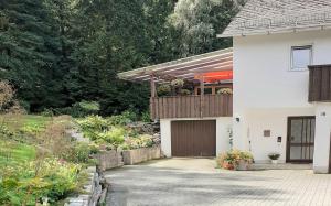 a white house with a deck and a garage at Ferienwohnung Oberschieda in Kirchenlamitz