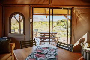 a dining table and chairs in a train car with a view at Ontevreden Farm in Montagu