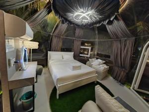 ein Schlafzimmer mit einem Bett, einem Tisch und einem Sofa in der Unterkunft The Coco Journey - Eco Dome in Malakka