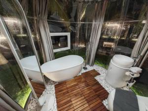 a bathroom with a bath tub and a toilet at The Coco Journey - Eco Dome in Melaka