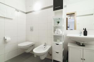 a white bathroom with a toilet and a sink at ALPSTAY "Platzhirsch" - XL Garten, Gondelnähe & Netflix in Bad Kleinkirchheim