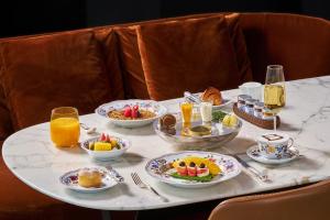a table filled with breakfast foods and orange juice at Bulgari Hotel Shanghai in Shanghai