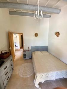 a bedroom with a bed and a chandelier at Mas Contemporain classée 3 étoiles -Piscine-A 400 m de la mer in Carry-le-Rouet