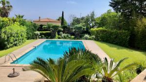 a swimming pool in a garden with trees and bushes at Mas Contemporain classée 3 étoiles -Piscine-A 400 m de la mer in Carry-le-Rouet