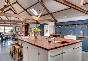 a kitchen with a wooden counter top and blue cabinets at The Cattle Shed in Wighton