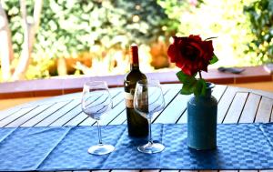 un tavolo con una bottiglia di vino e due bicchieri di vino di Azzurro Mare - Cornino a Custonaci