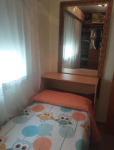 a small bedroom with a bed and a mirror at Ático con terraza en el puerto de Aguadulce in Aguadulce