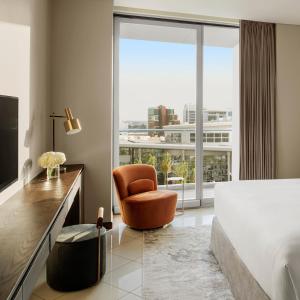 InterContinental Residence Suites Dubai Festival City, an IHG Hotel في دبي: غرفة نوم بسرير وكرسي ونافذة كبيرة