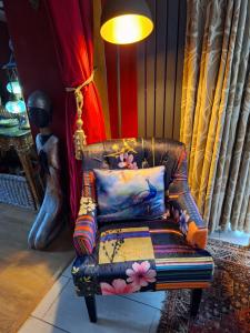 a chair sitting in a room with a lamp at Park House Matlock in Matlock