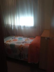 a bed in a room with a window with curtains at Ático con terraza en el puerto de Aguadulce in Aguadulce