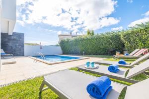 een achtertuin met een zwembad en tuinmeubilair bij Villas Novochoro - Small Garden in Albufeira