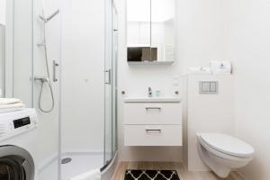a white bathroom with a toilet and a shower at Apartment in Northern Gdynia by Renters in Gdynia