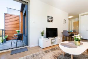 a living room with a table and a tv at Apartment in Northern Gdynia by Renters in Gdynia