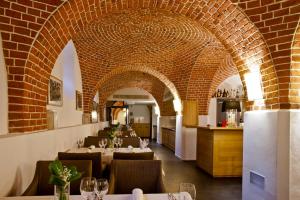 a restaurant with tables and chairs and a brick wall at Great Polonia The Granary La Suite Hotel in Wrocław