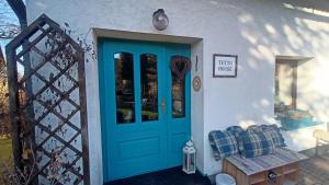 a blue door on a white house with a bench at TUTTO House&Home in Lubno