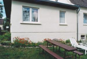 dos bancos frente a una casa blanca en Gemütliche Ferienwohnung, separater Eingang, 