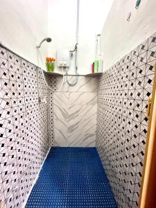 y baño con ducha y suelo azul. en Cozy 255 Entire 3 Bedroom House At Alma Bukit Mertajam en Bukit Mertajam