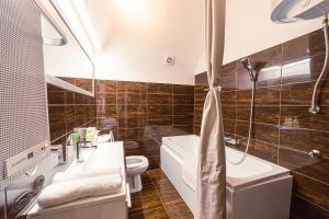 科塞格的住宿－Komló Apartman - Stefan，浴室配有盥洗盆、卫生间和浴缸。