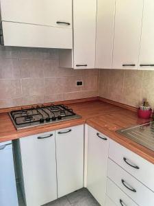 a kitchen with white cabinets and a stove at VILLAGGIO ANDORA COLOMBO in Marina dʼAndora