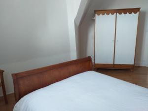 een slaapkamer met een bed en een kast bij Le Repaire de l'Armateur in Granville