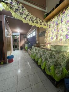 a restaurant with green chairs and a table with flowers on the wall at Lai Tada Homestay Sarikei in Sarikei