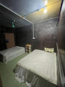 um quarto com duas camas num quarto com uma parede em Lai Tada Homestay Sarikei em Sarikei
