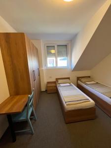 a room with two beds and a desk and a window at Terasa in Novi Sad