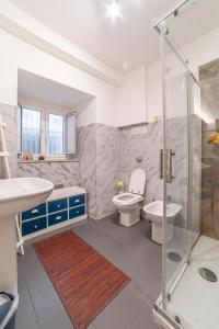 La salle de bains est pourvue de toilettes, d'un lavabo et d'une douche. dans l'établissement Natoli Apartments, à Palerme