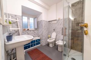La salle de bains est pourvue d'un lavabo, de toilettes et d'une douche. dans l'établissement Natoli Apartments, à Palerme