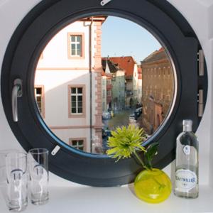 a mirror on a table with glasses and a window at Hôtel Quatorze in Colmar